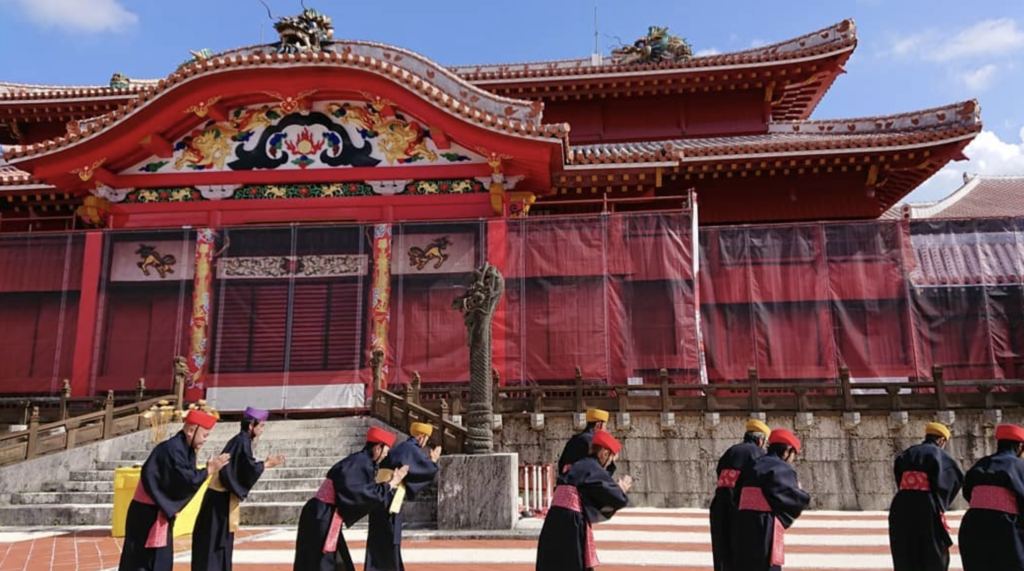 2018年の火災前の首里城正殿と百人御物参の再現行事